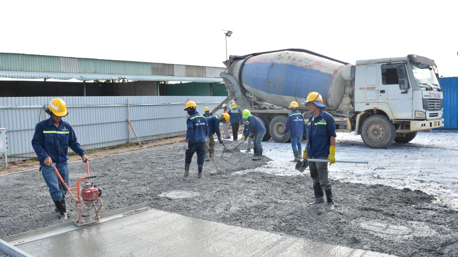 Construction crew placing and leveling concrete at an active jobsite