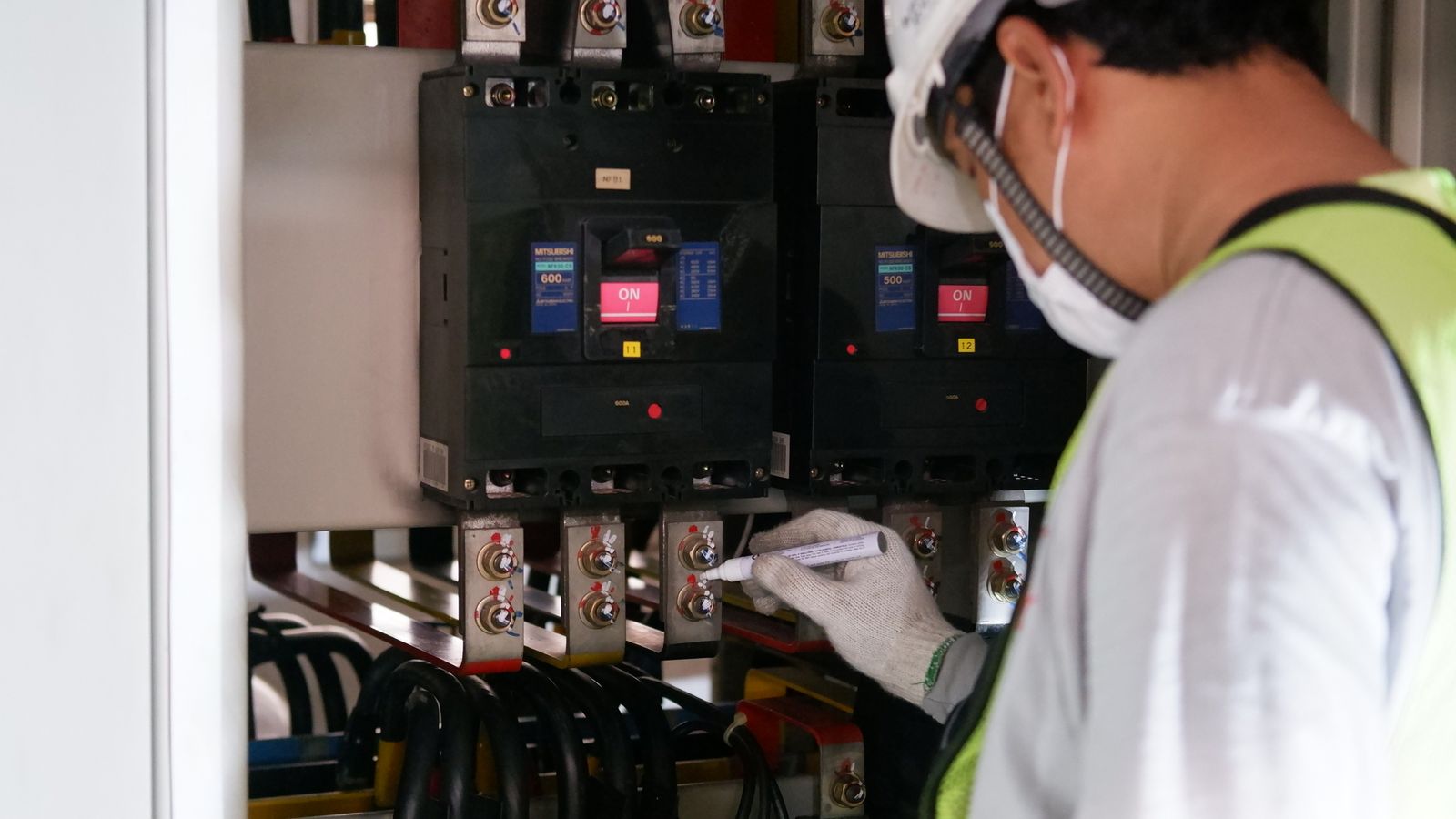 Electrical technician inspecting industrial power distribution equipment